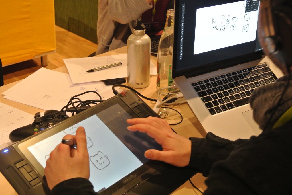 Una persona disegna un gatto con tavoletta grafica durante una game jam